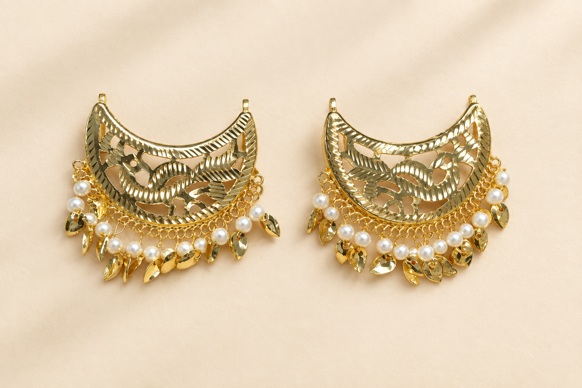 Gold-and-pearl earrings on a warm ivory background