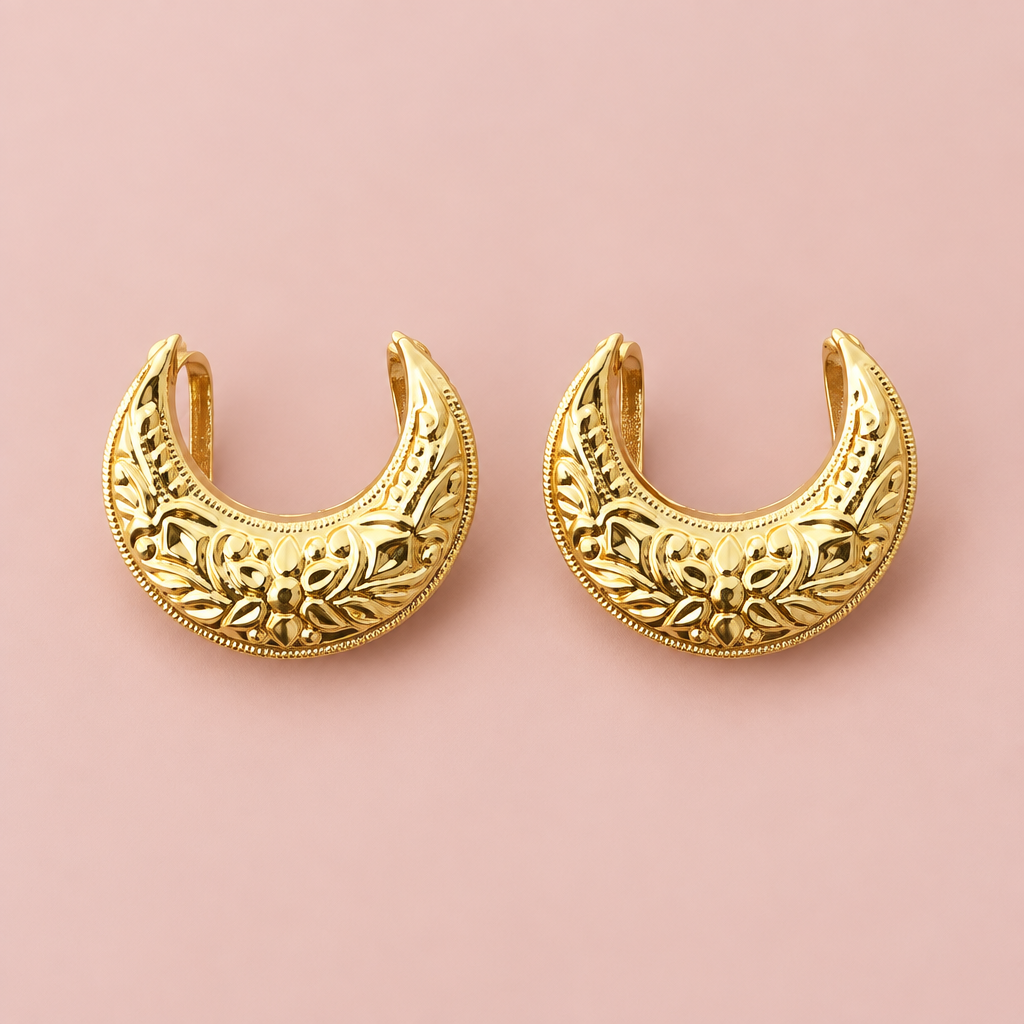 Gold earrings on a soft blush background