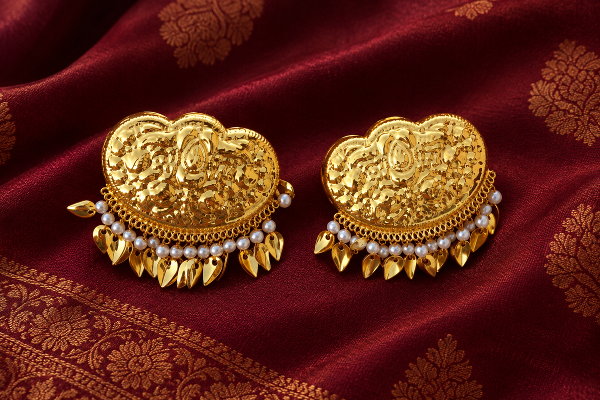 Gold earrings on a traditional burgundy backdrop