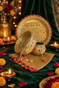 Gold Karwa Chauth thali set on a festive jewel-toned background
