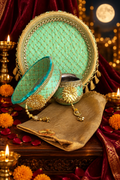 Mint green and gold Karwa Chauth thali set on deep maroon velvet with diyas